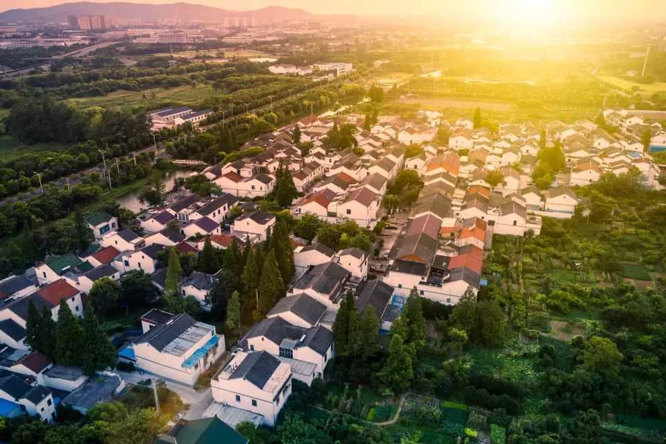 Aerial view of single-family homes in Houston suburb with setting sun in background